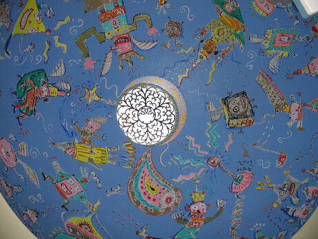 Looking up at the dome that was painted by Hamish. A variety of people and other objects are shown against a field of blue.