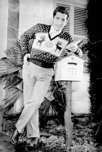 A young Tohsiro Mifune is leaning over a Japanese mailbox with some recently received letters in his hand, looking quite handsome in a Christmas sweater with two deer and a snowflake on it.
