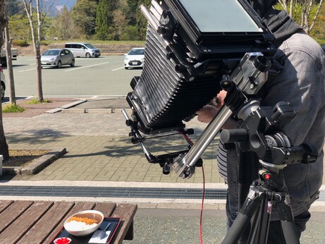 Man photographing plate of japanese curry with an 8x10 large-format camera. 
