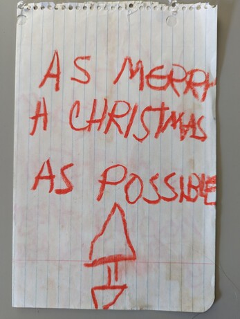 A note in a child's handwriting reading "As merry a Christmas as possible"