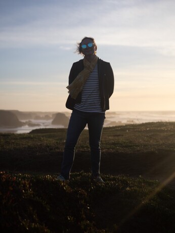 Nicole wearing her frank sunglasses, back lit, oceanside, trans and amazing. 