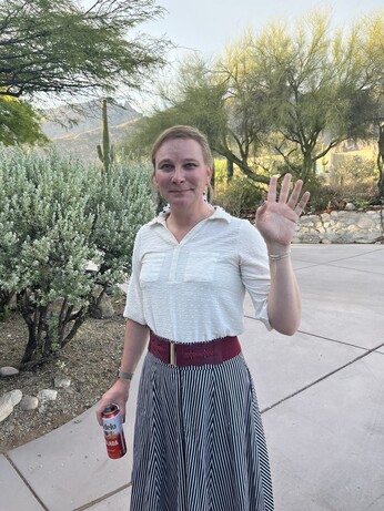 Nicole waving from the driveway that, until recently, was a field of broken branches and other previously-airborne debris. 